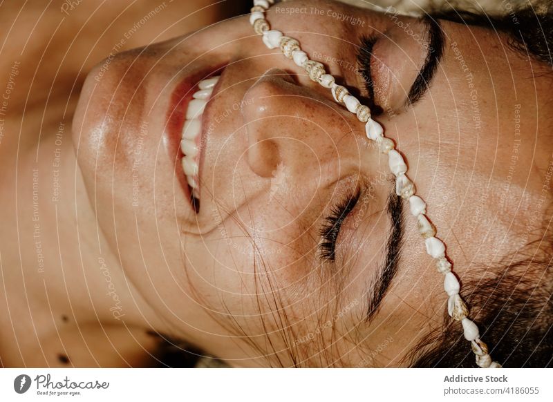 Ruhige glückliche Frau am sandigen Meeresufer mit Muscheln im Gesicht liegend Sonnenbad Strand Augen geschlossen Wulst sich[Akk] entspannen friedlich Feiertag