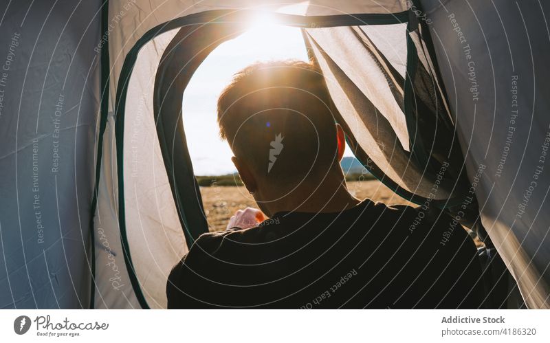 Anonymer männlicher Camper, der sich während einer Wandertour im Hochland im Zelt erholt Mann Lügen Lager Berge u. Gebirge Natur Hügel Wanderung Reisender