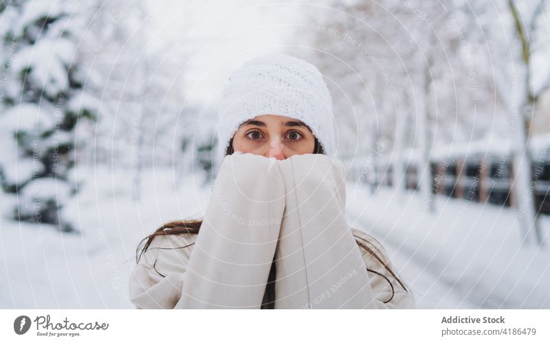 Unerkennbare, erstaunte Frau, die ihr Gesicht in der winterlichen Stadt verdeckt Deckblatt Erstaunen Überrascht Angst Schnee Winter Porträt kalt Wetter Tierhaut