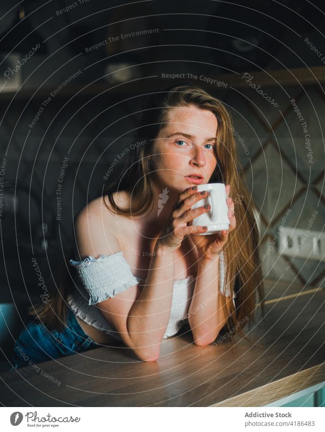 Attraktive junge Frau mit einer Tasse Heißgetränk in der Küche Gelassenheit positiv trinken Abfertigungsschalter ruhig charmant anlehnen nackte Schultern