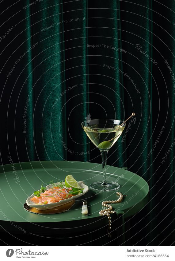 Edle Halskette auf dem Tisch neben leckerem Lachssnack und Wermut Aperitif Perle Messer Alkohol elegant Gastronomie schmackhaft Feinschmecker Lebensmittel Küche