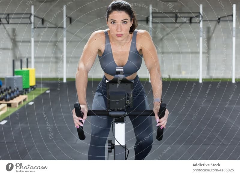 Starke Sportlerin trainiert auf dem Fahrrad im Fitnessstudio Training Zyklus operativ Mitfahrgelegenheit Übung aktiv muskulös Frau Athlet Gesundheit Aktivität