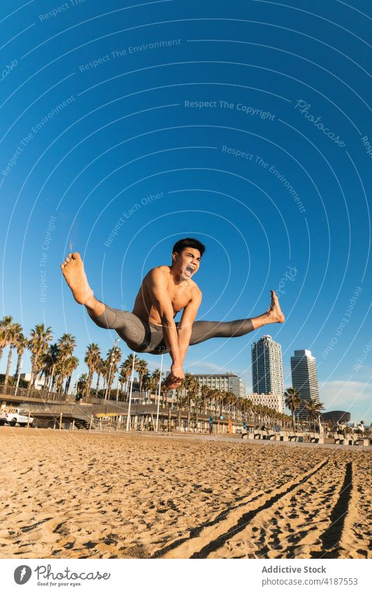 Starker Mann springt beim Outdoor-Training hoch Sportler springen Kraft stark Übung schreien Sprung Fitness jung asiatisch ethnisch ohne Hemd intensiv Lifestyle