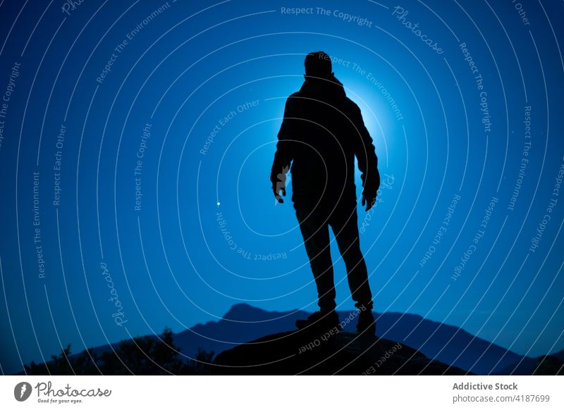 Silhouette eines anonymen Reisenden, der den blauen Himmel bei Nacht betrachtet Tourist nachdenken Blauer Himmel Reittier Natur Hochland Sonnenuntergang Ausflug