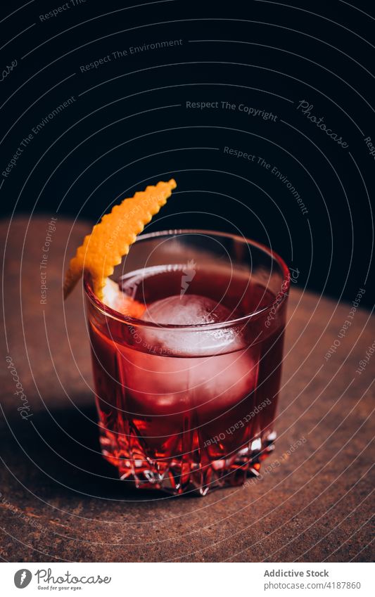 Ein Glas klassischer Negroni-Cocktail auf der Sofalehne negroni Alkohol Erfrischung trinken Getränk bitter Mischung Gin Wermut Eis mischen orange