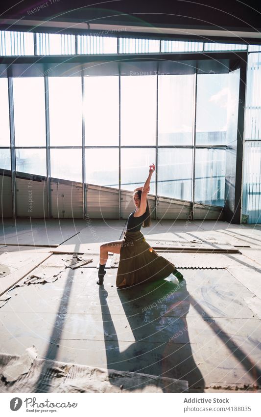 Tänzerin tanzt während einer Probe im Gebäude Künstler Tanzen Choreographie Bein angehoben Arm angehoben ausführen Schatten Theater Frau vorbereiten üben