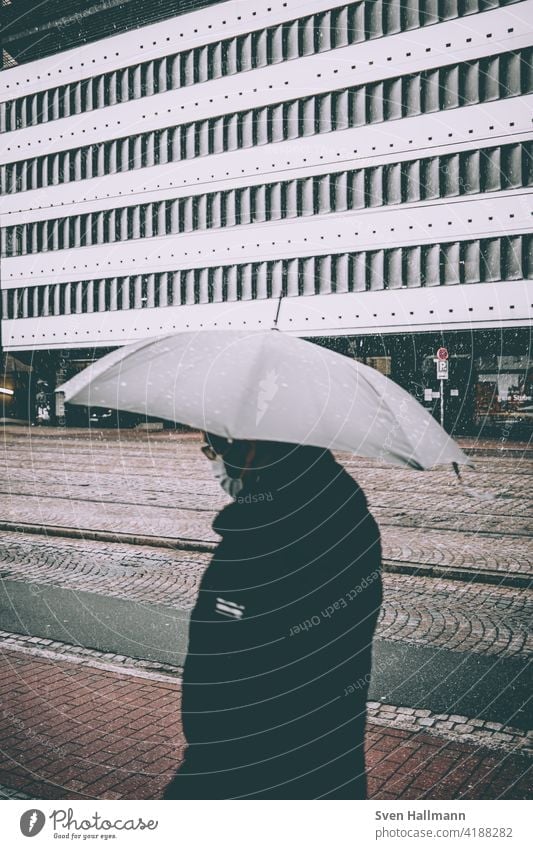 Spaziergänger im Regen mit Schirm Architektur Regenschirm Schnee Unwetter street Wetter nass regnerisch Herbst saisonbedingt im Freien regnet Wasser Großstadt