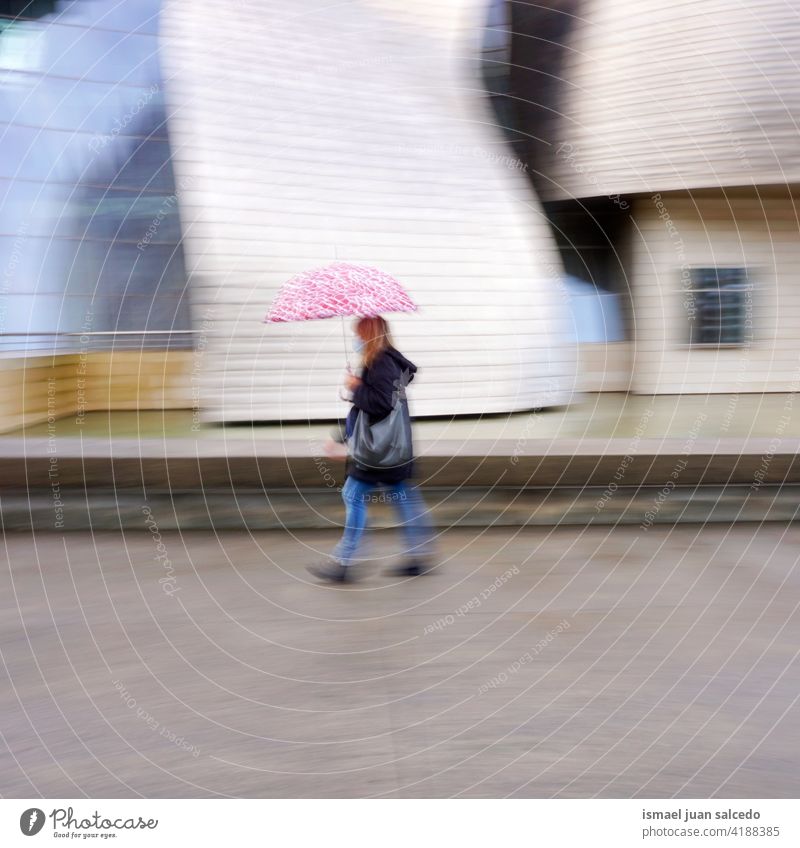 unscharfe Frau mit Regenschirm bei Regen in Bilbao, Spanien Erwachsener eine Person regnerisch regnet Tag Regentag Wasser menschlich Fußgänger Straße Großstadt