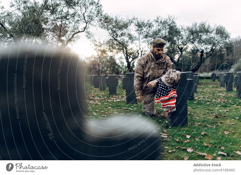 Kniender Soldat in der Nähe eines Soldatenfriedhofs Mann knien Trauer Friedhof Militär Held Zerreißen Gedenkstätte Opfer Respekt zwängen Armee Krieger Munition