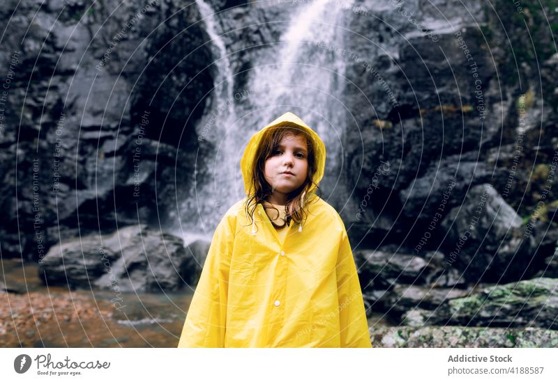 Mädchen in gelbem Regenmantel vor einem Wasserfall in den Bergen Berge u. Gebirge Tourismus Hochland Natur Fernweh reisen verträumt Kaskade schnell fließen