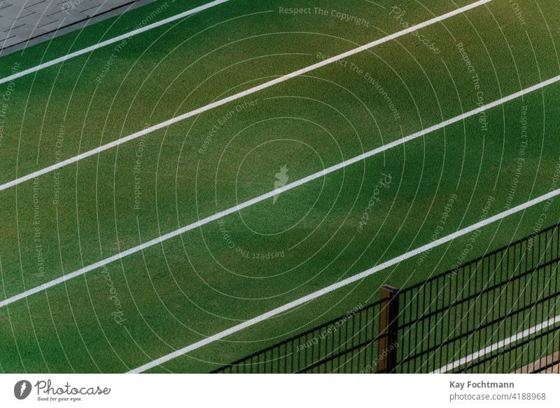 weiße Linien auf grüner Rennstrecke Arena Leichtathletik Hintergrund farbenfroh konkurrieren Konkurrenz Kurs Opferbereitschaft Entfernung leer Übung Feld Gras