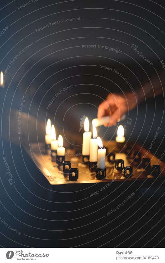 Kerzen in einer Kirche anzünden glaube beten Gebetskerzen Hand Licht Glaube Hoffnung Kerzenschein Weihnachten trauer