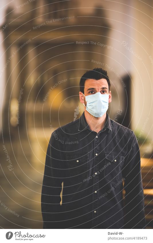 Mann mit Mundschutz in einer Kirche Corona pandemie ängste Glaube existenzängste coronavirus Hoffnung Gott beten ausdruckslos Angst