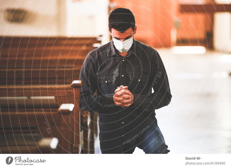 Mann mit Mundschutz / Maske in der Kirche Corona Atemschutzmaske beten knien Gebet Hoffnung Glaube Ängste Zukunftsangst Verzweiflung existenzängste pandemie