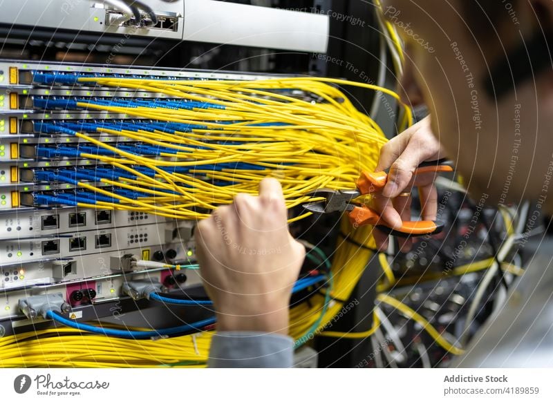 Professioneller Systemadministrator schneidet Drähte im Server Mann Ingenieur Draht geschnitten Drahtschneider Anschluss elektronisch Software Einrichtung