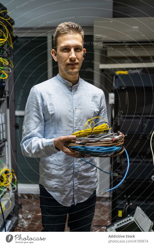 Männlicher Ingenieur mit Kabeln im Serverraum Mann Draht Headset Netzwerk elektronisch Vorrichtung automatisieren männlich Kontrolle Kraft Flugzeugwartung