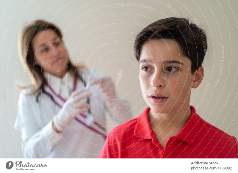 Arzt gibt Spritze für verängstigten Jungen Kind Einspritzung Impfstoff Coronavirus Schmerz wehtun Bund 19 COVID19 Pandemie Leckerbissen Infektion medizinisch