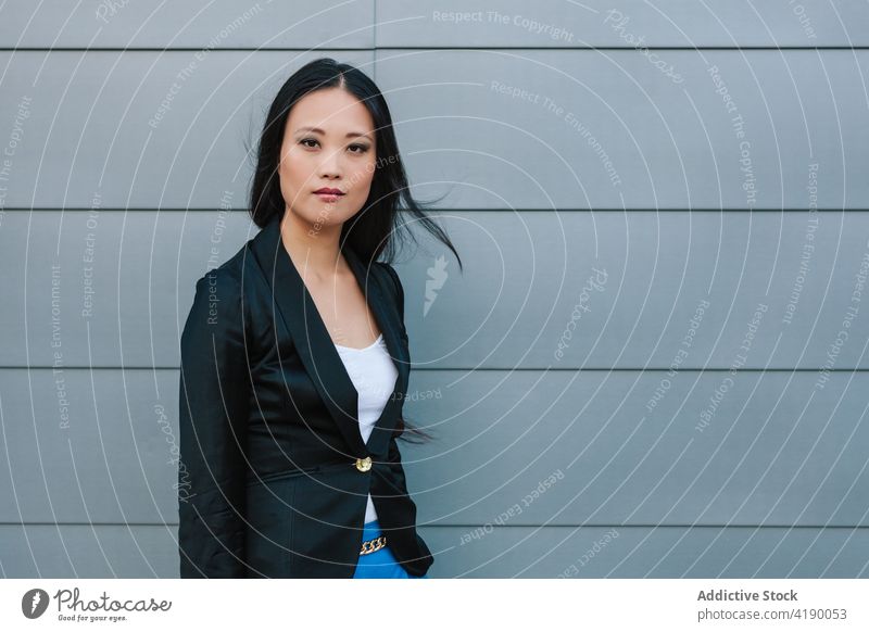 Ethnische Geschäftsfrau auf der Straße in der Nähe eines Gebäudes Spaziergang selbstbewusst Stil Unternehmer urban gut gekleidet Großstadt Frau asiatisch