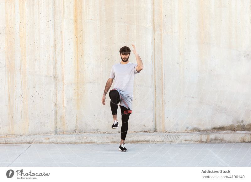 Aktiver Sportler, der mit einem Widerstandsband über den Laufsteg springt springen Aktivität Aufwärmen Herz Training Straßenbelag Mann Gesunder Lebensstil