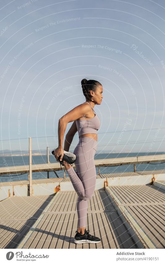 Ethnischer Sportler trainiert auf dem Gehweg unter dem Dach Athlet Übung Training Wohlbefinden Gesunder Lebensstil Vitalität Frau Straßenbelag Sportlerin üben