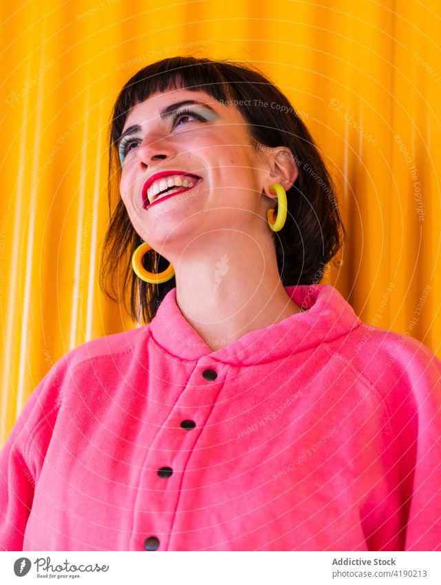 Positive Frau in lebhaftem Outfit in der Stadt ausgefallen cool urban Mode trendy heiter pulsierend Freude Metall Wand gelb Großstadt Lächeln rote Lippen Stil