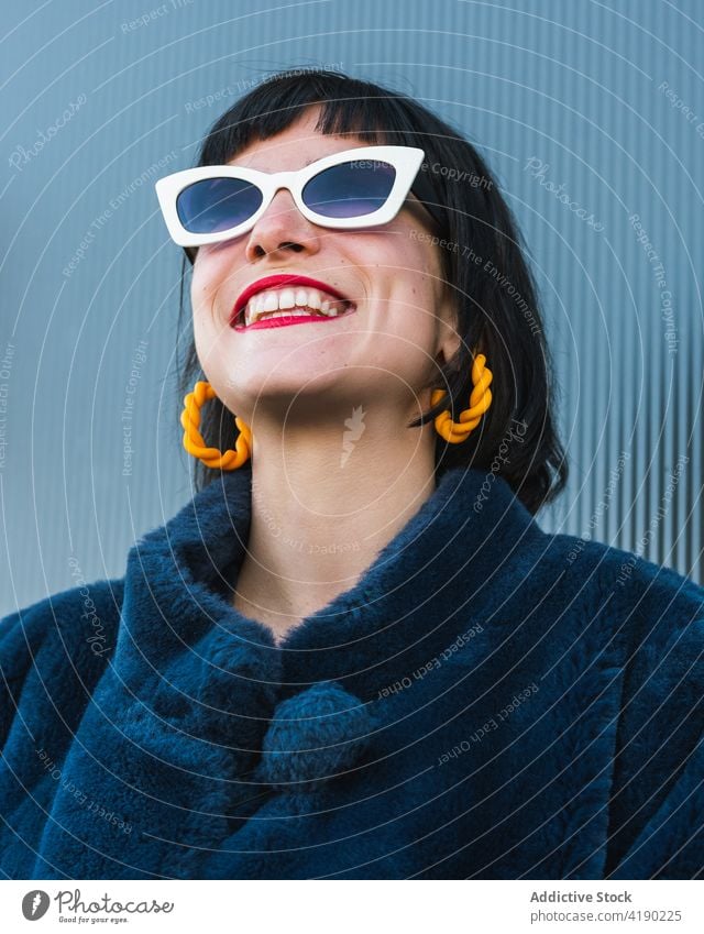 Stylische Frau mit trendiger Sonnenbrille in der Stadt ausgefallen Mode lebhaft trendy cool Outfit urban Freude Metall Wand Großstadt Lächeln rote Lippen Stil