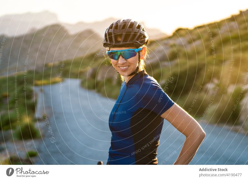 Fröhliche Frau mit Fahrrad in der Natur Sport Aktivität Radfahrer ruhen Pause Windstille aktiv Sportlerin Schutzhelm Berge u. Gebirge allein Gesundheit