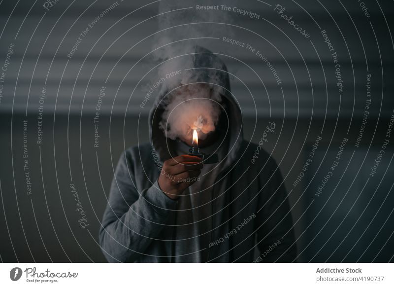 Anonymer Mann zündet sich in der Dunkelheit eine Zigarette an Rauch Feuerzeug Dunst Süchtige Habitus Tabak Raucherin Brandwunde Nikotin inkognito männlich