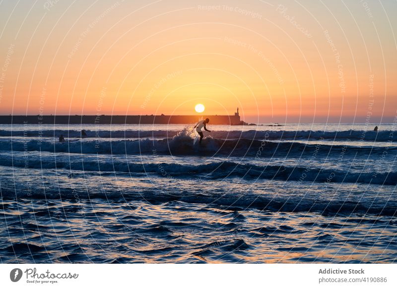 Menschen genießen Surfboarding im Meer bei Sonnenuntergang Silhouette Surfer MEER Tourist winken schwimmen Meereslandschaft Surfen Tourismus Wasser Sonnenlicht