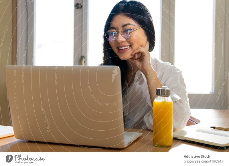 Asiatische Frau mit Brille arbeitet an einem Laptop Business benutzend Apparatur freiberuflich Fokus Anschluss Arbeit Beruf Konzentration Inbetriebnahme