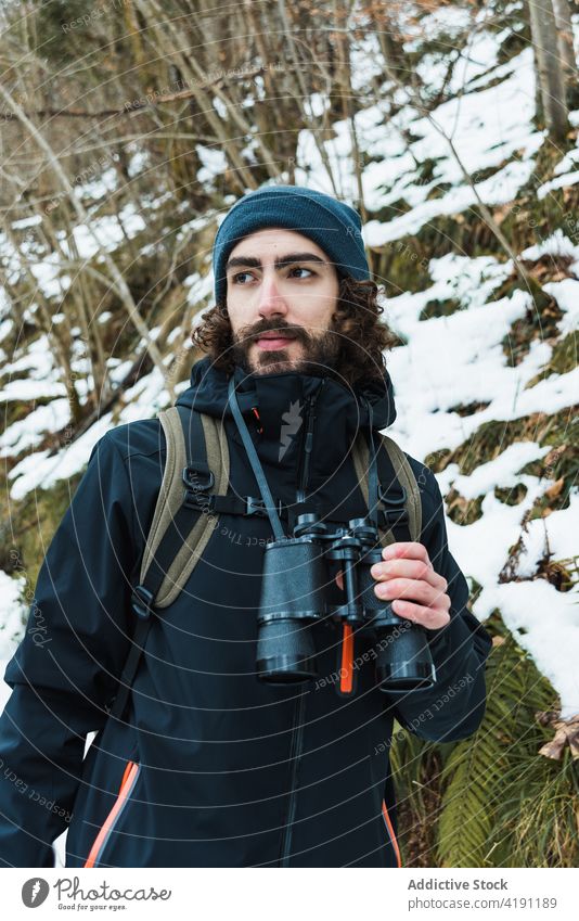 Reisender Mann mit Fernglas im Winterwald reisen Wald Abenteuer Wanderer erkunden warme Kleidung männlich Saison Schnee Natur Wälder Urlaub Tourismus
