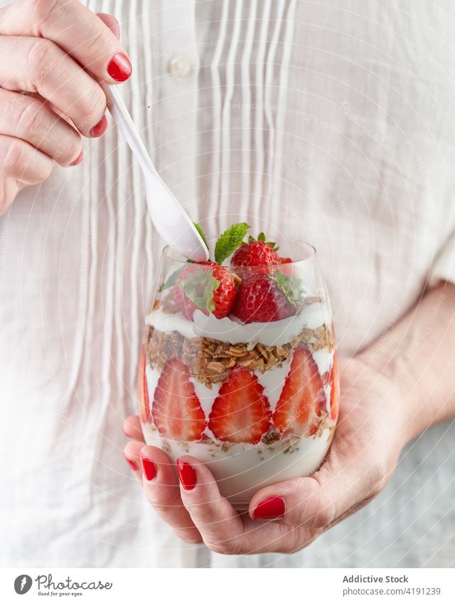 Crop-Frau mit einem Glas köstlichen Frühstücks mit frischen Erdbeeren gesunde Ernährung Supernahrung Kraftschale Nährstoff Vitamin geschmackvoll durchsichtig