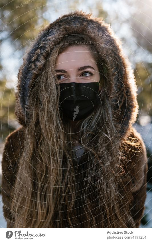 Frau mit Maske im Winterwald Wald Wälder Schnee Mundschutz behüten Coronavirus sonnig schlendern COVID kalt Saison verhindern Sicherheit Wetter Pandemie Seuche