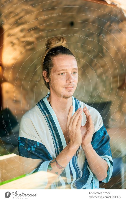 Hipster-Mann mit betenden Händen auf dem Bürgersteig Namaste Yoga Sprit Wellness Gesunder Lebensstil Vitalität Straßenbelag Porträt betende Hände Dehnung
