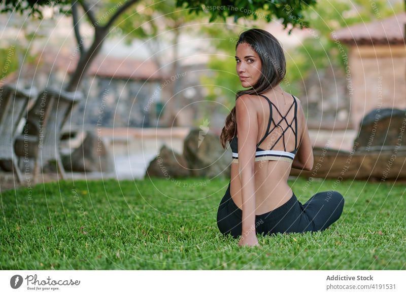 Frau übt Yoga auf einer Wiese im Innenhof üben Gesunder Lebensstil Energie Vitalität Wohlbefinden Hof Porträt Körper Kurve beweglich Dehnung Rasen Wellness
