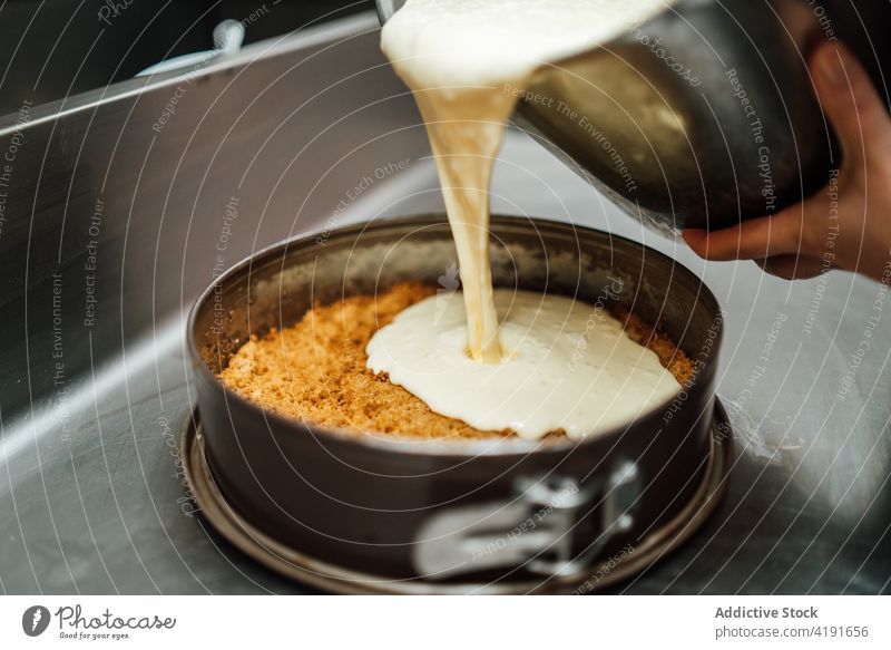 Anonymer Koch kocht leckeren Käsekuchen in der Küche vorbereiten Café Büchse eingießen Form Formular Metall Dessert süß kulinarisch Feinschmecker Lebensmittel