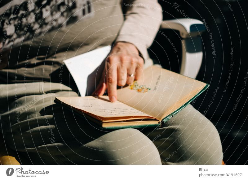 Eine Frau blättert in einem alten Poesiealbum oder Tagebuch Erinnerungen Freundschaftsalbum blättern Buch Buchseite