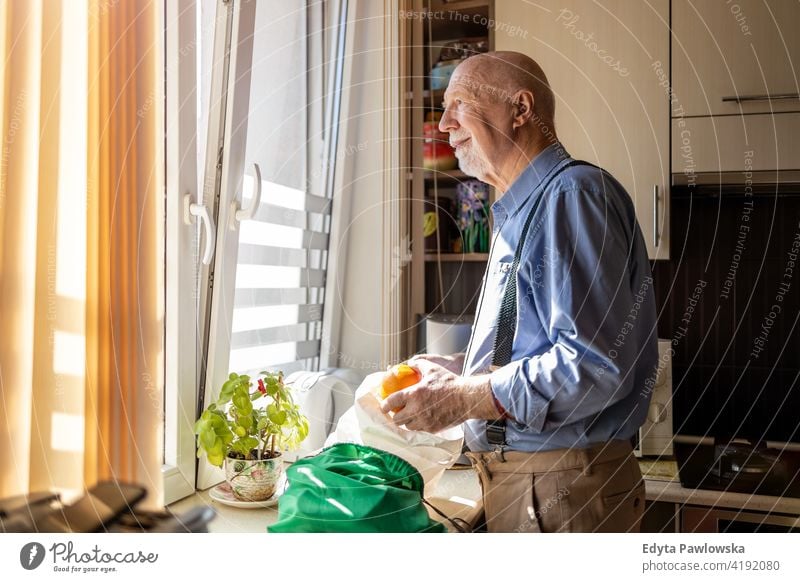 Senior Mann Blick durch Fenster zu Hause echte Menschen offen reif männlich Kaukasier älter heimwärts alt Alterung häusliches Leben Großvater Rentnerin