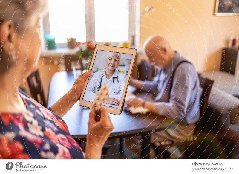 Älteres Paar berät sich mit einem Arzt auf einem digitalen Tablet echte Menschen offen Frau Senior reif männlich Mann Zusammensein Liebe Bonden Kaukasier älter