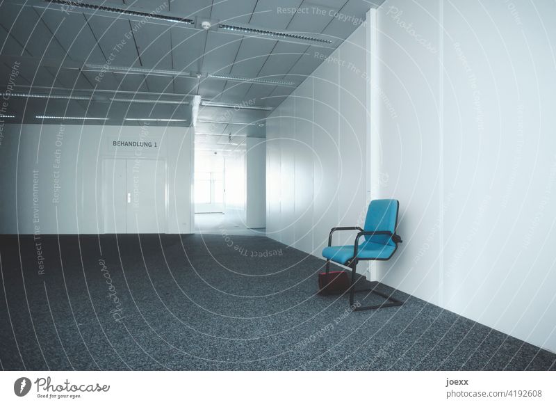 Kalter anonymer Warteraum vor Behandlungszimmer mit blauem Stuhl und vergessenener Handtasche Warten Wartezimmer für Ärzte grau steril einsam warten