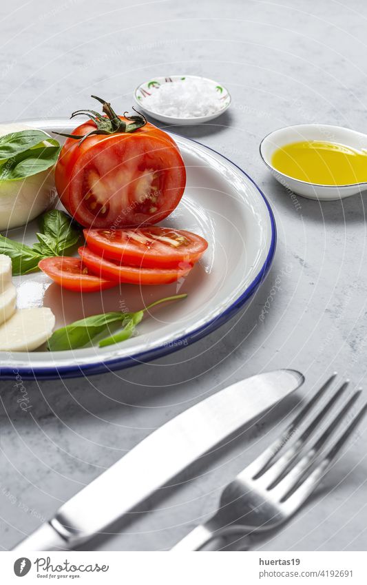Hausgemachter italienischer Caprese-Salat mit geschnittenen Tomaten, Mozzarella-Käse, Basilikum und Olivenöl Salatbeilage Lebensmittel mediterran Italienisch
