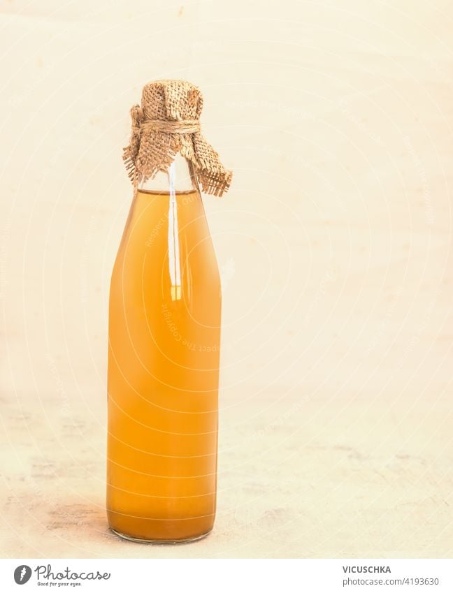 Flasche mit selbstgemachtem Apfelsaft oder Essig auf dem Küchentisch. Stilleben Saft Tisch Stillleben Bestandteil roh Vitamin Getränk Glas natürlich trinken