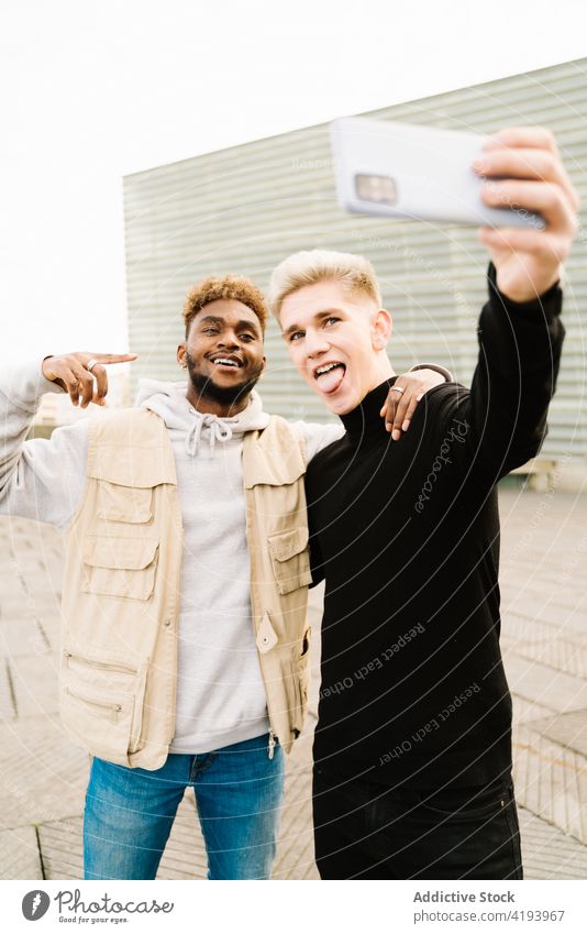 Positive junge männliche Freunde machen ein Selbstporträt mit ihrem Smartphone auf der Straße Männer Selbstportrait teilen Lächeln Glück Zusammensein