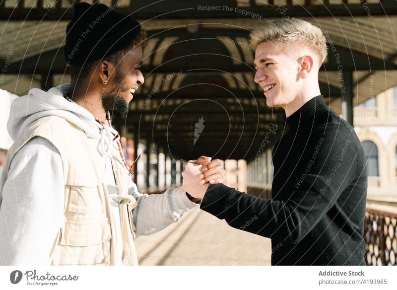 Trendy multiethnischen Männer geben dap nach der Sitzung auf der Straße Hände schütteln Gruß trendy Freund Zusammensein Großstadt Stil Partnerschaft positiv