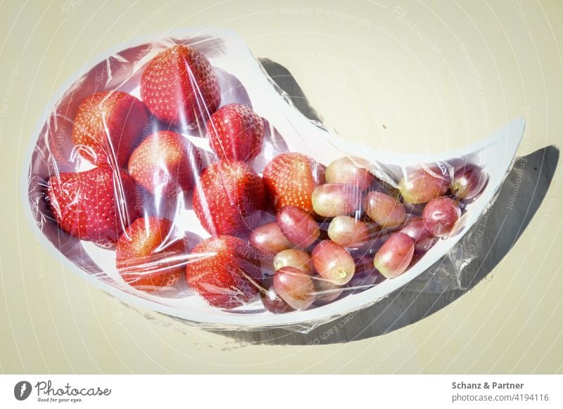 In Frischhaltefolie verpackte Erdbeeren und Trauben Obst Buffet Fructose Früchte natürlich unnatürlich schwitzen Lebensmittel Frucht frisch Ernährung süß