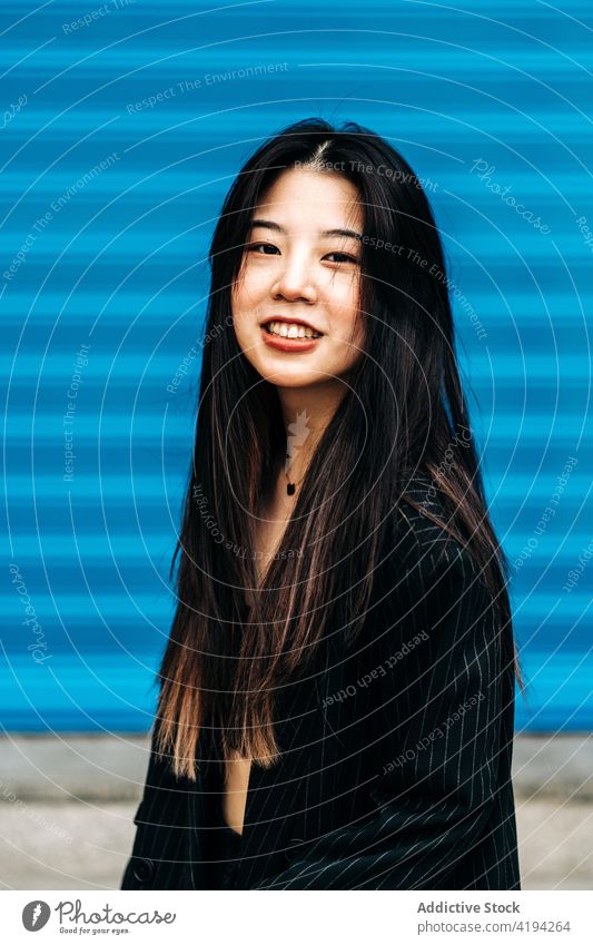 Lange Haare brünette asiatische Frau Blick auf Kamera mit einem blauen Hintergrund Japanisch Asien jung Model Chinesisch Stil attraktiv Dame Straße modern