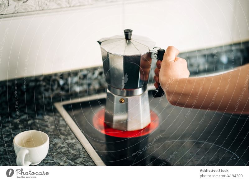 Moka-Kaffeekanne auf der heißen Herdplatte zu Hause Topf Mokka brauen Espresso Aroma Küche heimwärts Metall Material glänzend Kunststoff Handgriff Knauf