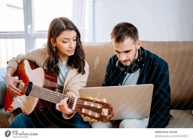Ehepaar nimmt zu Hause ein Lied auf Paar Aufzeichnen Musik Gesang Musiker Gitarre spielen heimwärts Laptop akustisch Sofa Apparatur Gitarrenspieler Melodie