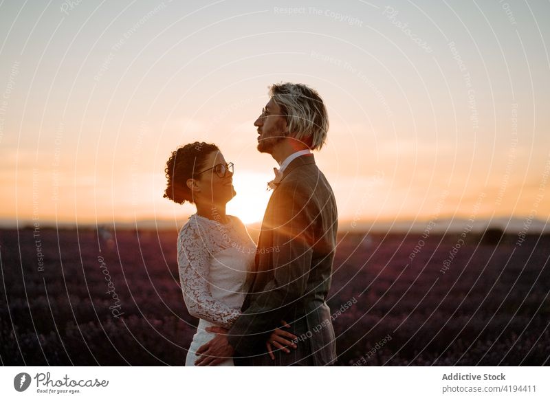 Frischvermählte in der Abenddämmerung auf einem Feld stehend Paar Jungvermählter Sonnenuntergang romantisch Natur Valentinsgruß Angesicht zu Angesicht Anlass