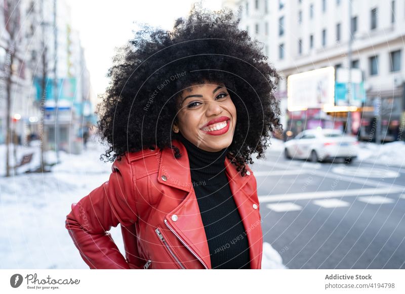 Schwarze Frau mit Afro-Haar auf der Straße und lächelt in die Kamera Afro-Look Afroamerikaner schwarz Stil Großstadt urban Optimist Individualität krause Haare